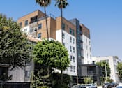 Thumbnail 43 of 46 - A modern building with a palm tree in front at Skylar At Sunset Apartments, Los Angeles, CA