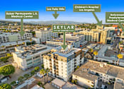 Thumbnail 45 of 46 - An aerial view of a city with a building named SKYLAR at the center.
