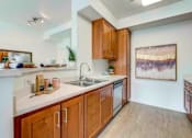 Thumbnail 52 of 53 - A kitchen with wooden cabinets and a white countertop.