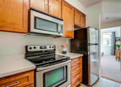 Thumbnail 45 of 53 - A kitchen with a black refrigerator, stove, and microwave.