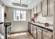 Thumbnail 2 of 16 - A kitchen with a stove top oven and a window.