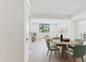 Thumbnail 20 of 157 - A dining room with a table and chairs.