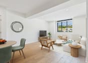 Thumbnail 19 of 157 - A living room with a green chair and a wooden table.