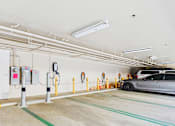 Thumbnail 40 of 40 - A parking garage with a car parked and multiple charging stations.