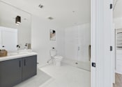 Thumbnail 23 of 157 - A bathroom with a white toilet and a white sink.