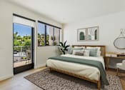 Thumbnail 10 of 157 - A bedroom with a large bed and a view of the outside through the sliding glass doors.
