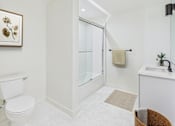 Thumbnail 14 of 157 - A white bathroom with a toilet, sink, and shower.