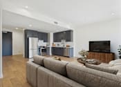 Thumbnail 2 of 157 - A modern living room with a grey sofa and a wooden coffee table.