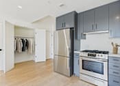 Thumbnail 1 of 157 - A kitchen with a stainless steel refrigerator and oven, and wooden flooring.
