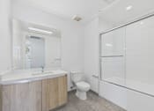 Thumbnail 38 of 45 - A white bathroom with a wooden vanity and a walk-in shower.