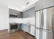 Thumbnail 34 of 45 - A modern kitchen with stainless steel appliances and wooden flooring.
