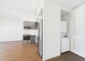 Thumbnail 36 of 45 - A white refrigerator is in a kitchen with a microwave and oven.