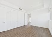 Thumbnail 39 of 45 - A room with white walls and wood flooring with three white doors.
