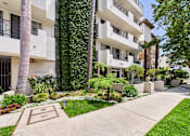Thumbnail 13 of 16 - A white apartment building with a green lawn in front.