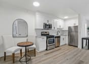 Thumbnail 31 of 66 - a kitchen with white cabinets and stainless steel appliances and a table