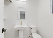 Thumbnail 35 of 66 - a bathroom with a sink and a toilet and a mirror