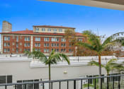 Thumbnail 33 of 66 - a view of a building from a balcony with palm trees