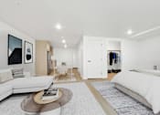Thumbnail 24 of 54 - A modern bedroom with a large bed and a white couch.