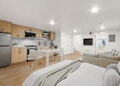Thumbnail 43 of 54 - A modern kitchen with a dining table and a couch.