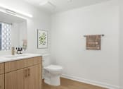 Thumbnail 42 of 54 - A white toilet sits in a bathroom with a brown towel hanging on the wall.