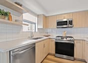 Thumbnail 4 of 54 - A modern kitchen with wooden cabinets and stainless steel appliances.