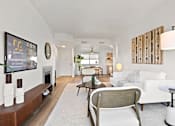 Thumbnail 3 of 54 - A living room with a white couch and a wooden chair.