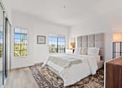 Thumbnail 9 of 54 - A bedroom with a large bed and a view of the outside.