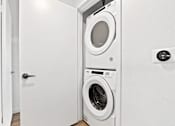 Thumbnail 5 of 54 - A white door is open to a laundry room with a washer and dryer.