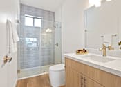 Thumbnail 7 of 54 - A bathroom with a toilet, sink, and shower.