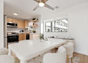 Thumbnail 50 of 54 - A modern kitchen with a white dining table and chairs.