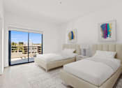 Thumbnail 52 of 54 - A bedroom with two beds and a balcony overlooking a building.