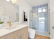 Thumbnail 51 of 54 - A bathroom with a white toilet and a glass shower door.