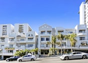 Thumbnail 22 of 54 - A modern apartment complex with a "Now Leasing" sign in front of it.