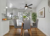 Thumbnail 3 of 19 - a dining area with a table and chairs and a ceiling fan