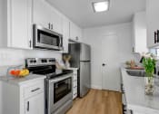 Thumbnail 2 of 19 - a kitchen with white cabinetry and stainless steel appliances