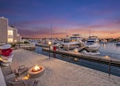 Thumbnail 19 of 251 - A boat is docked at a marina with a sunset in the background.