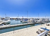 Thumbnail 21 of 251 - A marina with boats docked and a clear blue sky.