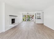 Thumbnail 3 of 251 - A spacious room with a fireplace and a view of the garden outside.