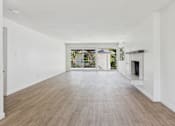 Thumbnail 4 of 251 - A spacious room with wooden flooring and white walls.