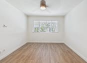 Thumbnail 10 of 251 - A room with a window and wooden flooring.