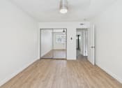 Thumbnail 11 of 251 - A white hallway with a wooden floor and a glass door.