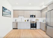 Thumbnail 2 of 52 - A modern kitchen with stainless steel appliances and wooden flooring.