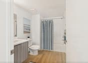 Thumbnail 19 of 52 - A bathroom with a toilet, sink, and shower curtain.