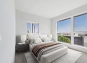Thumbnail 18 of 52 - A bedroom with a large bed and a view of the city.