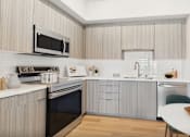 Thumbnail 16 of 52 - A modern kitchen with a black oven and a white countertop.
