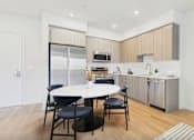 Thumbnail 22 of 52 - A modern kitchen with a dining table and chairs.