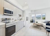 Thumbnail 11 of 52 - A modern kitchen with a stove top oven and microwave above it.