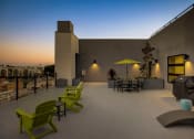 Thumbnail 15 of 31 - a patio with green chairs and yellow umbrellas at dusk