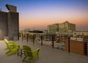 Thumbnail 14 of 31 - a view of the city skyline from a roof top patio with green chairs