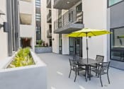 Thumbnail 7 of 31 - a patio with a table and chairs and a yellow umbrella